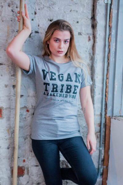 A female model wearing Unisex grey marl tshirt. designed by eco-ethical brand Viva La Vegan with the words Vegan Tribe across the front